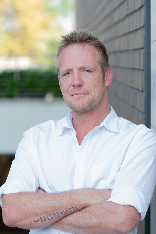 Man posing for staff photo in build serve branded shirt