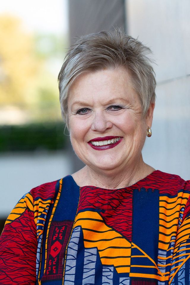 Woman posing for staff photo in build serve branded shirt
